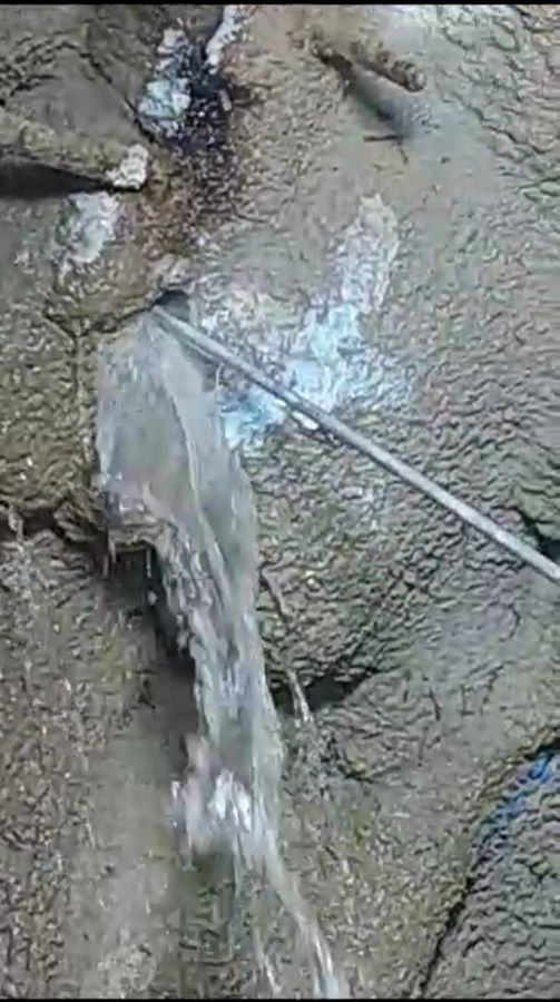 Agua fluyendo desde una fractura en la roca antes del sellado